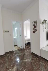 Habitación con paredes blancas y suelo de mármol. en Apartamento DREAM BAENA en Baena