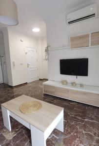 sala de estar con mesa y TV de pantalla plana en Apartamento DREAM BAENA en Baena