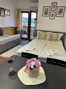Un dormitorio con una cama y una mesa con flores. en Apartman 'Tramonto' Srebrno Jezero, en Veliko Gradiste