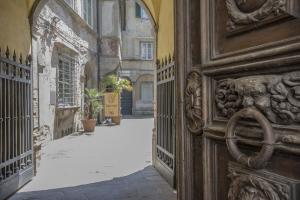 un vicolo con porta aperta in un edificio di A Palazzo Busdraghi Residenza D'Epoca a Lucca