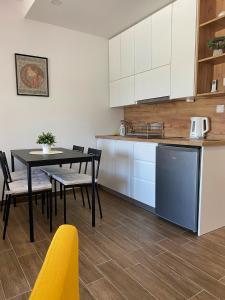 cocina y comedor con mesa y sillas en Apartman 'Tramonto' Srebrno Jezero, en Veliko Gradiste