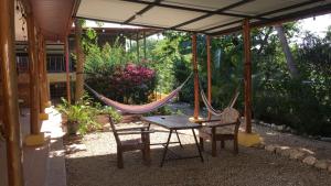 a patio with a hammock and a table and chairs at Casa Flores Carrillo - Monkey Cabena in Carrillo