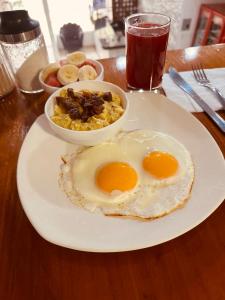 um prato com dois ovos e uma tigela de comida numa mesa em Fortune Hotel em Guayaquil