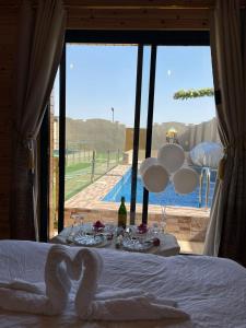 a bedroom with a bed with a view of a pool at كوخ الغصن الريفي in Jeddah