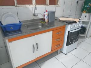 a small kitchen with a sink and a stove at casa vó doca, preço único pela casa inteira,cabem até 10 pessoas ao lado da basilica aparecida in Aparecida