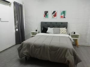 1 dormitorio con 1 cama grande y 2 mesas en Clover Hostel en Mendoza