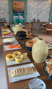 einem langen Tisch mit Teller mit Essen und Vasen darauf in der Unterkunft Mana Beach Experience in Ipojuca