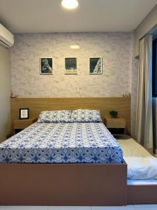 a bedroom with a bed with a blue and white comforter at Mana Beach Experience in Ipojuca