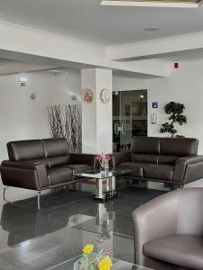 a lobby with two leather couches and a table at Europeia Hotel in Caldas da Rainha