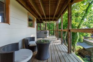 a screened porch with a table and chairs on a deck at NAPA Suite • Hot Tub • Downtown • Original Art in Eureka Springs