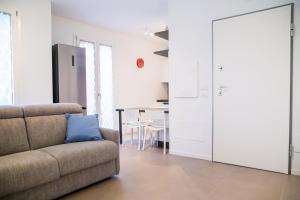a living room with a couch and a blue pillow at SUITE NAVIGLIO 26 in Parma
