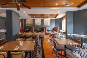 Rydges Southbank Townsville في تاونزفيل: غرفة طعام مع طاولات وكراسي خشبية