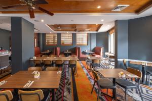 a dining room with wooden tables and chairs at Rydges Southbank Townsville in Townsville