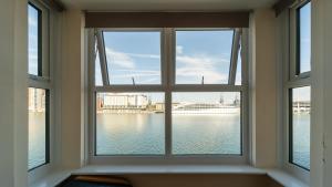 a window with a view of the water at Luxury Riverview 2Bed Apt- 5 mins from Excel London, Canary wharf, 02 Arena - Free Parking - PlayStation 4 Provided in London