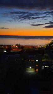 - une vue sur la ville au coucher du soleil sur l'océan dans l'établissement la mas linda ventana al mar, à Puerto Madryn