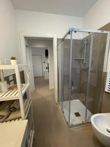 La salle de bains est pourvue d'une douche et d'un lavabo. dans l'établissement SUITE NAVIGLIO 26, à Parme