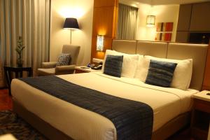 a hotel room with a large bed and a chair at The Place Gurugram, a member of Radisson Individuals in Gurgaon