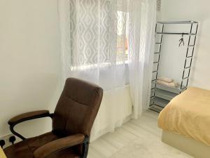 une chaise dans une chambre avec un lit et une fenêtre dans l'établissement Single room bentilee, à Bucknall