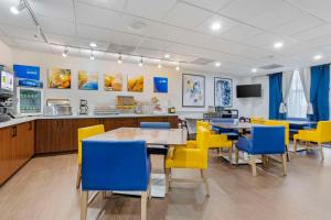 a dining room with yellow chairs and tables at Comfort Suites Houston NW - Vintage Park in Houston