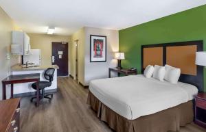 Habitación de hotel con cama grande y escritorio. en Extended Stay America Suites - Salt Lake City - Union Park, en Midvale