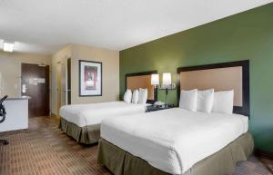2 Betten in einem Hotelzimmer mit grünen Wänden in der Unterkunft Extended Stay America Suites - Santa Barbara - Calle Real in Santa Barbara