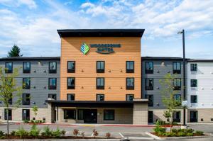 a building with a sign on the side of it at WoodSpring Suites Olympia - Lacey in Olympia