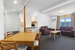 a living room with a dining room table and a couch at Econo Lodge East Adelaide in Adelaide