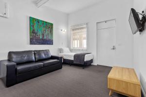 ein Wohnzimmer mit einem Sofa und einem Bett in der Unterkunft Econo Lodge East Adelaide in Adelaide