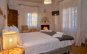 1 dormitorio con 1 cama grande y chimenea en Thalassoxyla Portaria, en Portaria