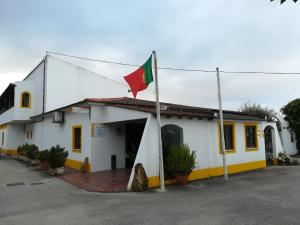 um edifício com uma bandeira em cima em Hotel Rural A Coutada em Atouguia da Baleia