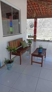 a porch with two benches and potted plants at EnjoyMaranhão Santo Amaro in Santo Amaro