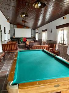 a pool table in a room with chairs at Hotel Rural A Coutada in Atouguia da Baleia