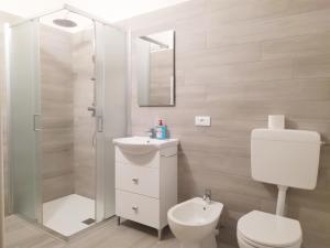 Un baño con inodoro, lavabo y ducha. en Trento Degasperi 16, en Trento