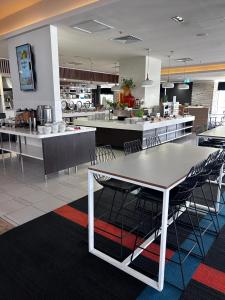a large kitchen with tables and chairs in a room at Stay in the heart of Surfers in Gold Coast