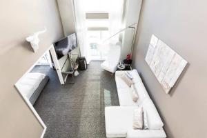 a living room with two white couches and a tv at Space Needle Downtown Modern Top Story Penthouse in Seattle