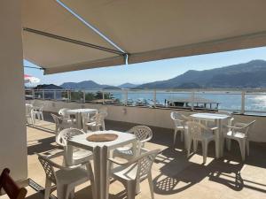 a balcony with tables and chairs and a view of the water at Suítes com Vista para o Mar no Marinas - Mirante do Marinas in Angra dos Reis