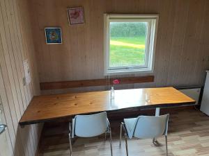 una gran mesa de madera en una habitación con ventana en Lundby Camping en Nibe