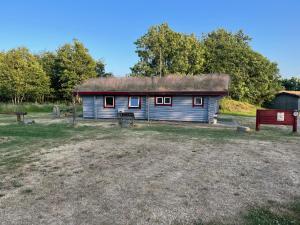 una casa vieja con techo de hierba en un campo en Lundby Camping, en Nibe