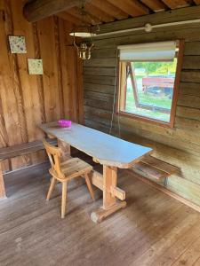 uma mesa de madeira e uma cadeira num camarote em Lundby Camping em Nibe