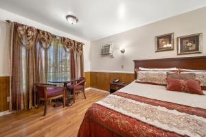 a bedroom with a bed and a desk and a table at Kingsway Inn in Caro