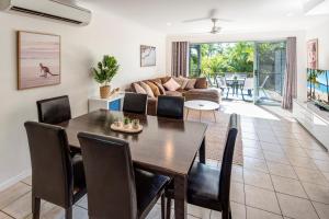 a living room with a dining table and a couch at Sunset Waters 1 by HamoRent on Hamilton Island in Hamilton Island +19 photos