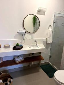 a bathroom with a sink and a mirror at Casa em Secretário (@chacaradosolsecretario) in Petrópolis