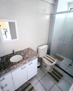 a bathroom with a toilet and a sink and a shower at Apartamento Praia de Ponta Verde com um quarto in Maceió