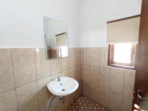 uma casa de banho com um lavatório e um espelho em torok ocean homestay em Mataram