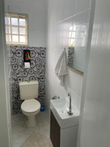 a white bathroom with a toilet and a sink at HOSTEL CAMINHO DA FE in Aparecida