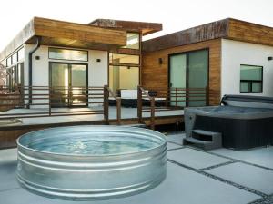 a hot tub on a patio with a house at Panoramic Heaven - Luxury Designer Property w Spa in Joshua Tree