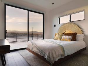 a bedroom with a large bed with a large window at Panoramic Heaven - Luxury Designer Property w Spa in Joshua Tree