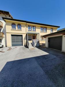 a large house with two garage doors and a driveway at Appartamento Peç in Sùtrio