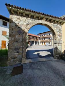 an archway in a stone building with a car behind it at Appartamento Peç in Sùtrio