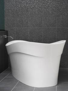 約書亞樹的住宿－Panoramic Heaven - Luxury Designer Property w Spa，浴室设有白色浴缸,浴室设有瓷砖墙